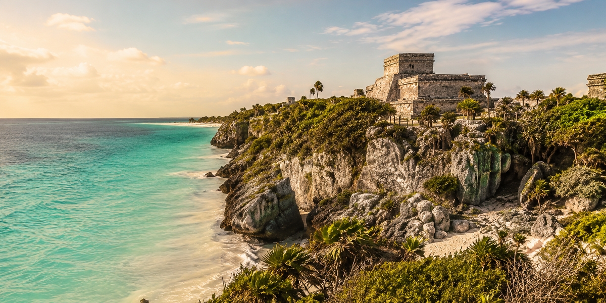 Храм El Castillo на краю скалы в Тулуме, за ним — Карибское море